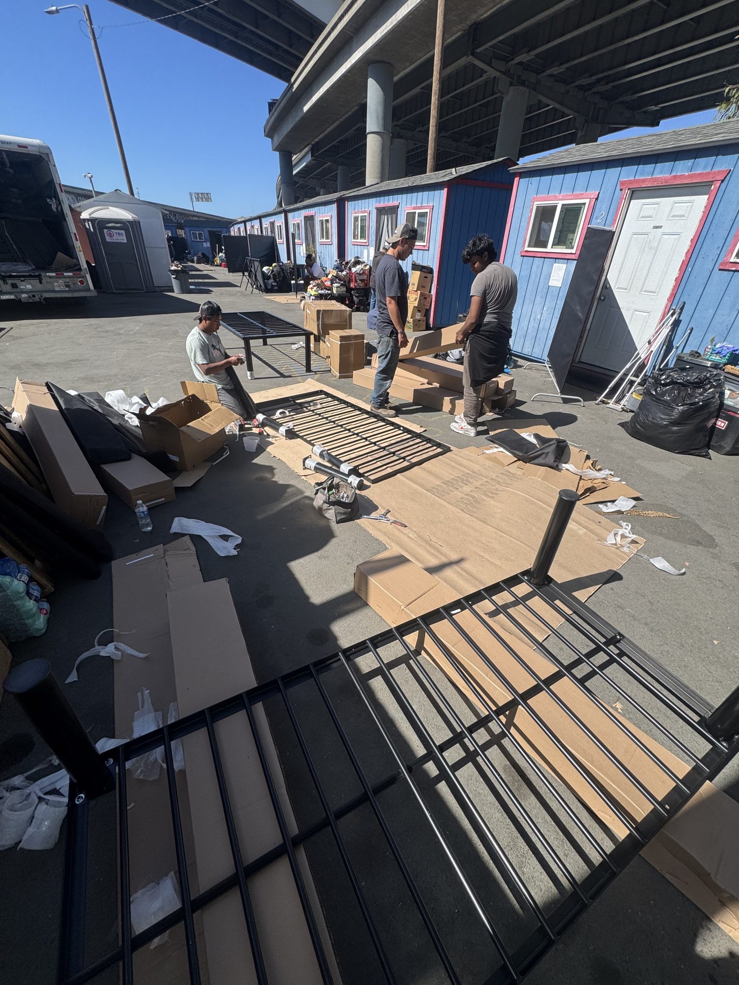 Crew unboxing bed frames between cabins